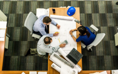 Three architects going over construction plans in their office